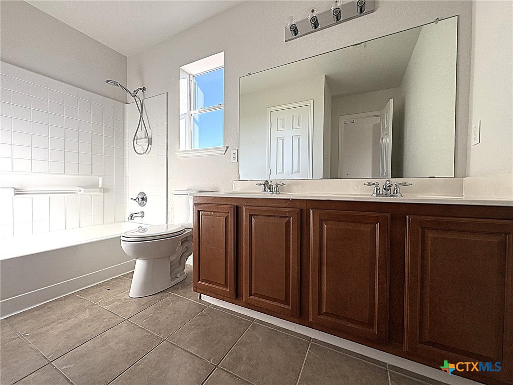6502 Griffith Loop Killeen, TX 76549 - Photo 18 of 22 a bathroom with a granite countertop sink mirror and a bathtub