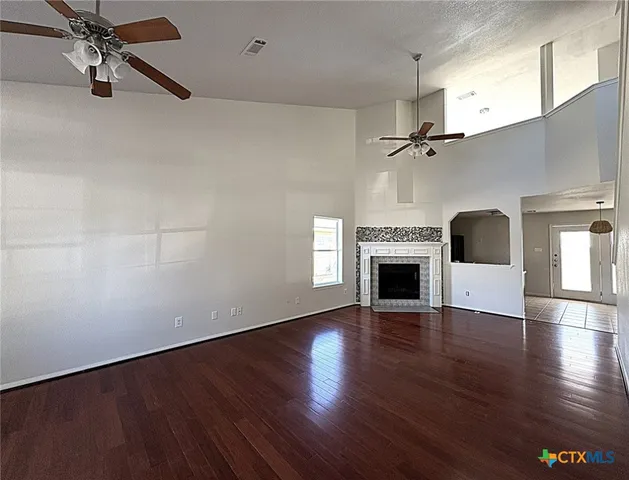 wooden floor fireplace and windows in an empty room
