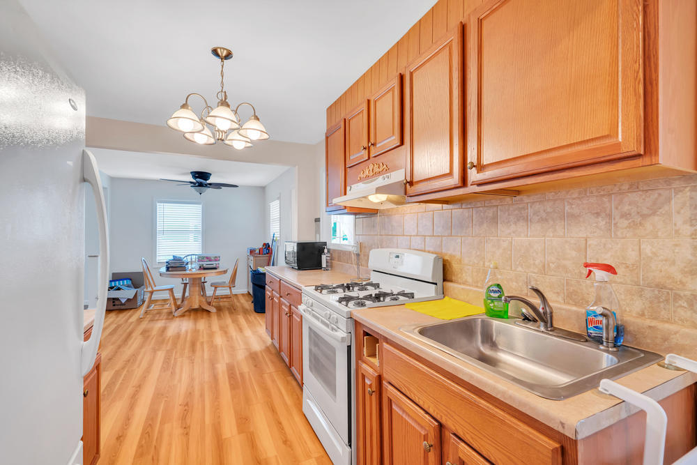 42 Harborage Avenue Bayville, NJ 08721 - Photo 11 of 35 a kitchen with a sink dining table and chairs