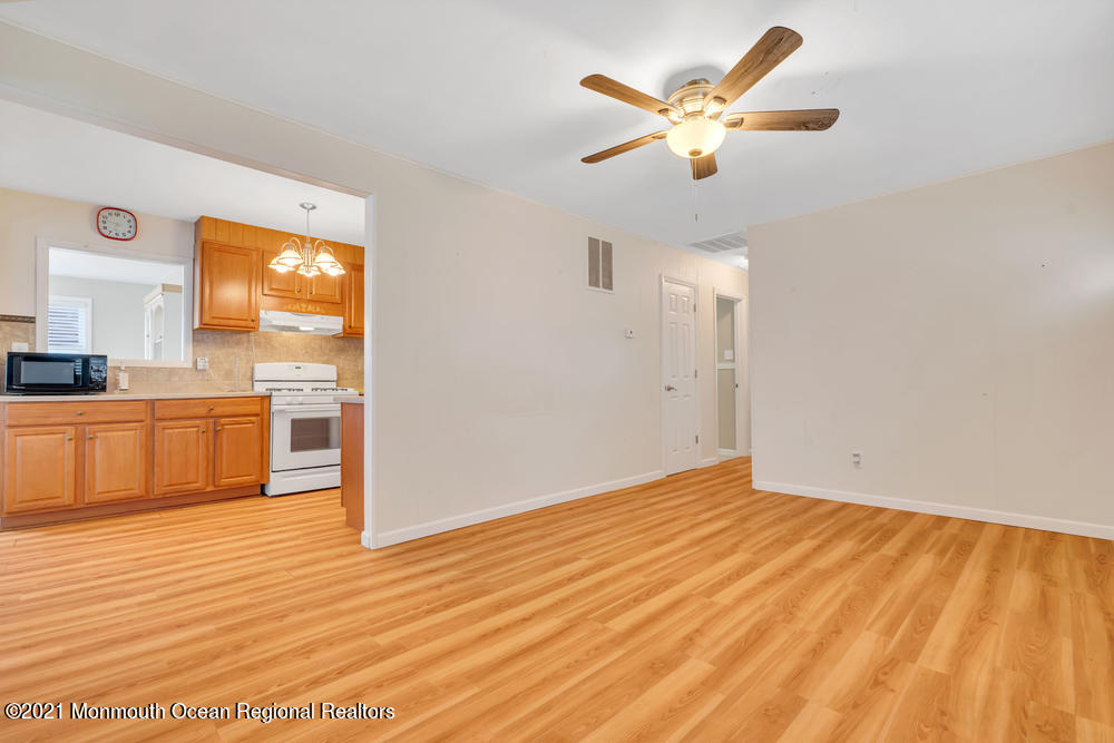 42 Harborage Avenue Bayville, NJ 08721 - Photo 7 of 35 a view of a kitchen with wooden floor and a ceiling fan