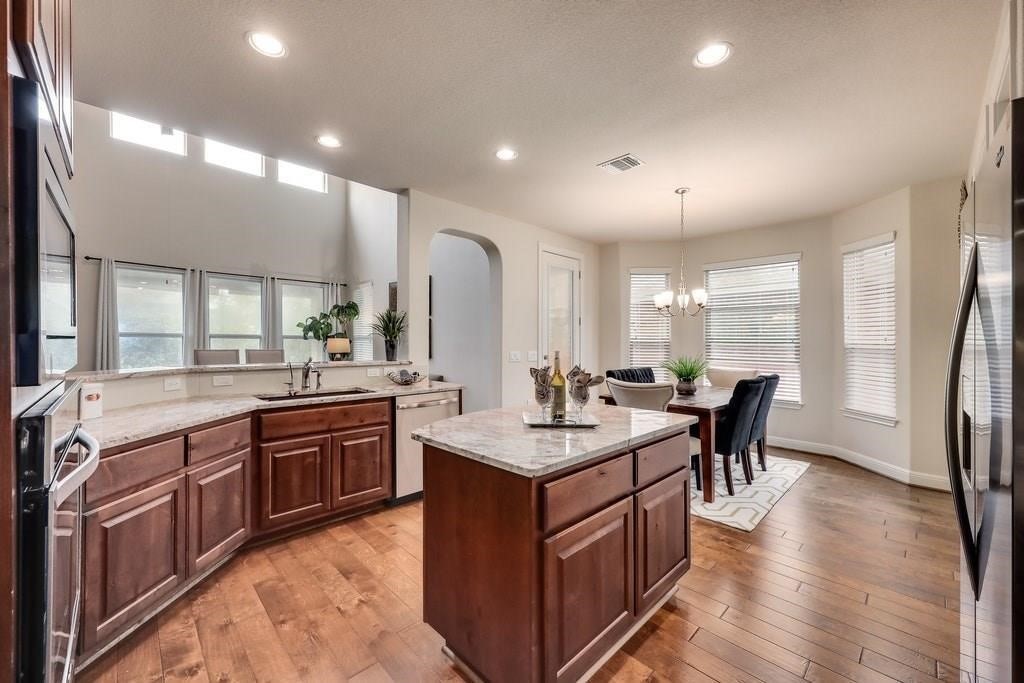 10825 Ballard Path Austin, TX 78717 - Photo 10 of 39 a large kitchen with stainless steel appliances a stove a sink dishwasher and a dining table with the living room