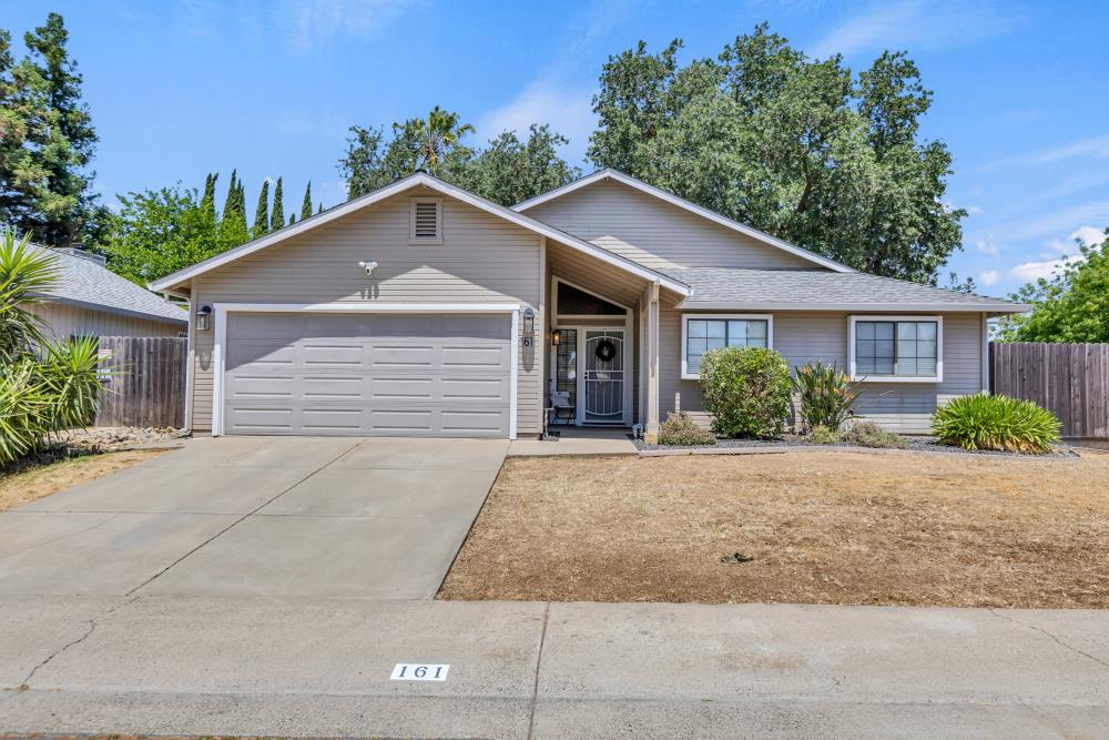 a front view of house with yard and trees in the background
