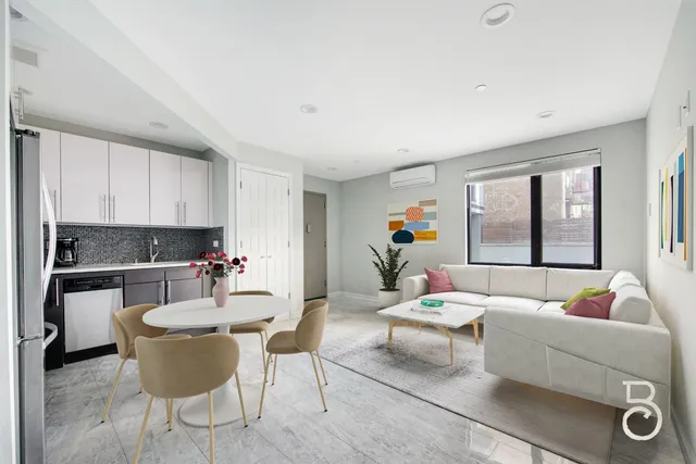 a living room with furniture and a dining table with kitchen view