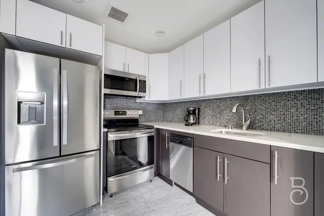 a kitchen with stainless steel appliances granite countertop a refrigerator sink and cabinets