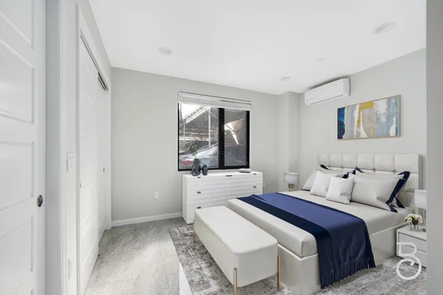 a bedroom with a bed and a large window