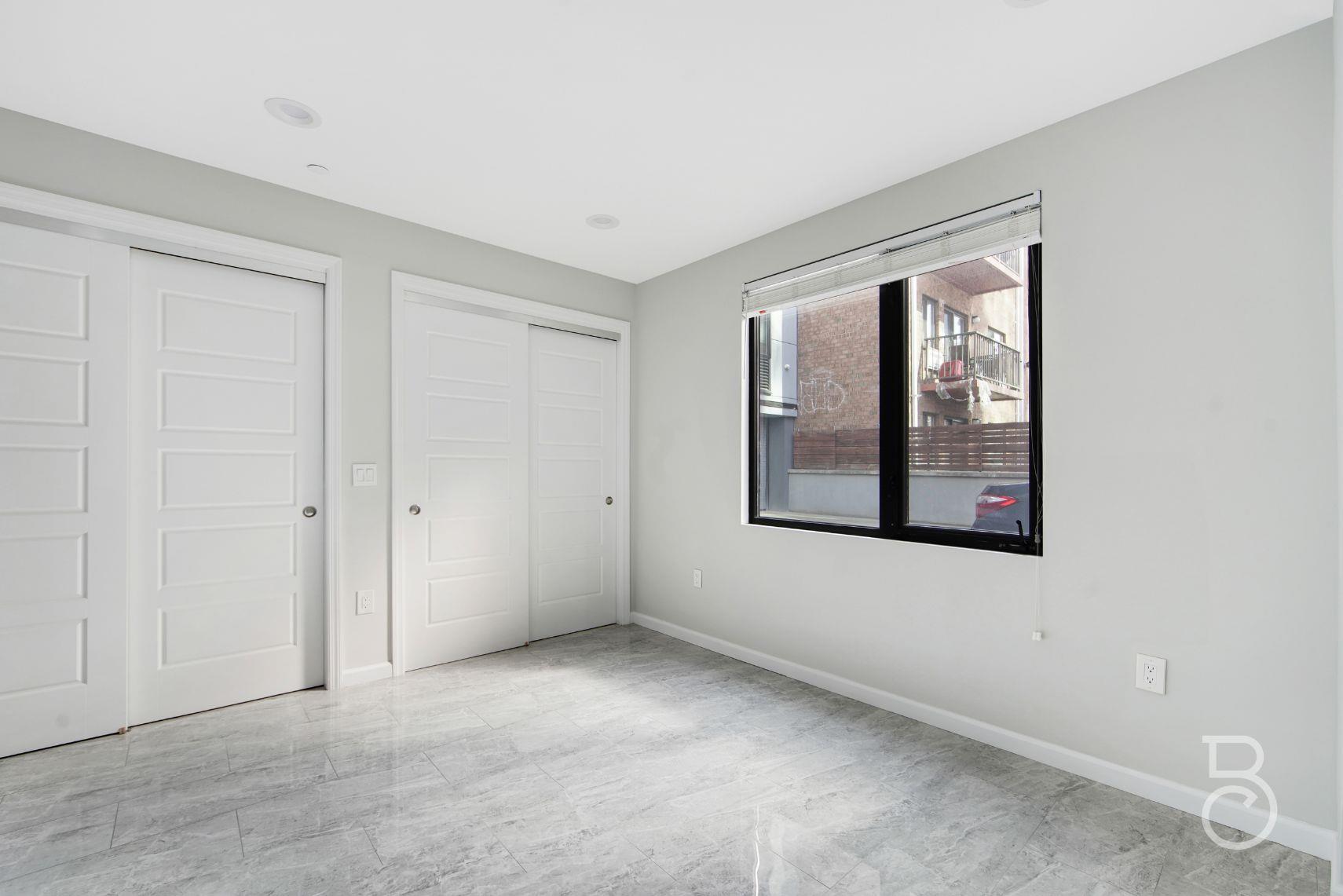 31-10 28th Road, Unit 1A Queens, NY 11102 - Photo 9 of 12 an empty room with windows