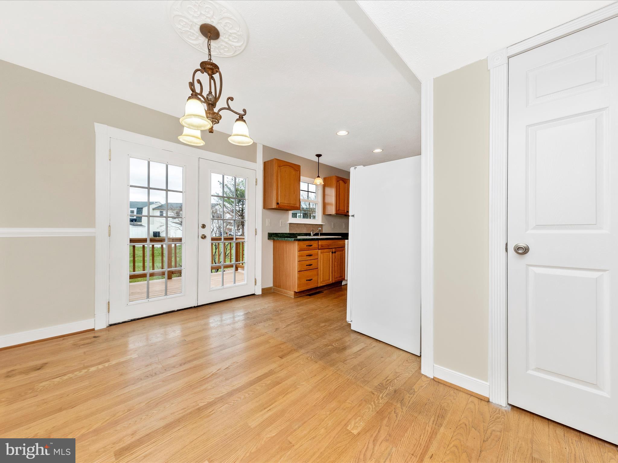 1116 Keswick Place Frederick, MD 21703 - Photo 10 of 53 a view of a kitchen with a refrigerator a ceiling fan and wooden floor