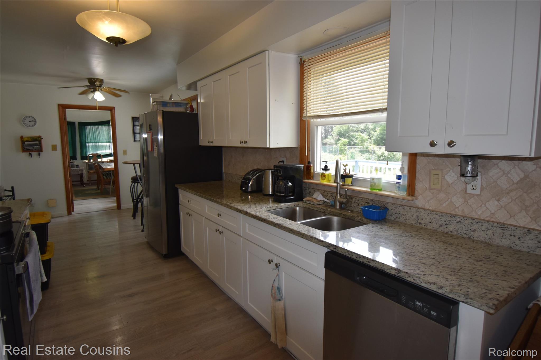 2247 Johnson Mill Road North Branch, MI 48461 - Photo 3 of 22 Kitchen featuring white shaker-style cabinetry, a double basin sink, and wood-finish flooring