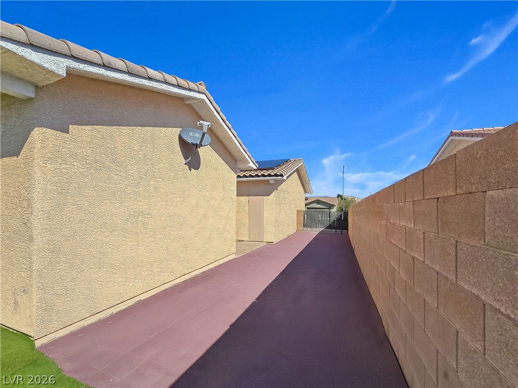 2485 Morrow Ridge Place Laughlin, NV 89029 - Photo 28 of 40 A private side yard path leads to a secured gate, offering convenient outdoor access.