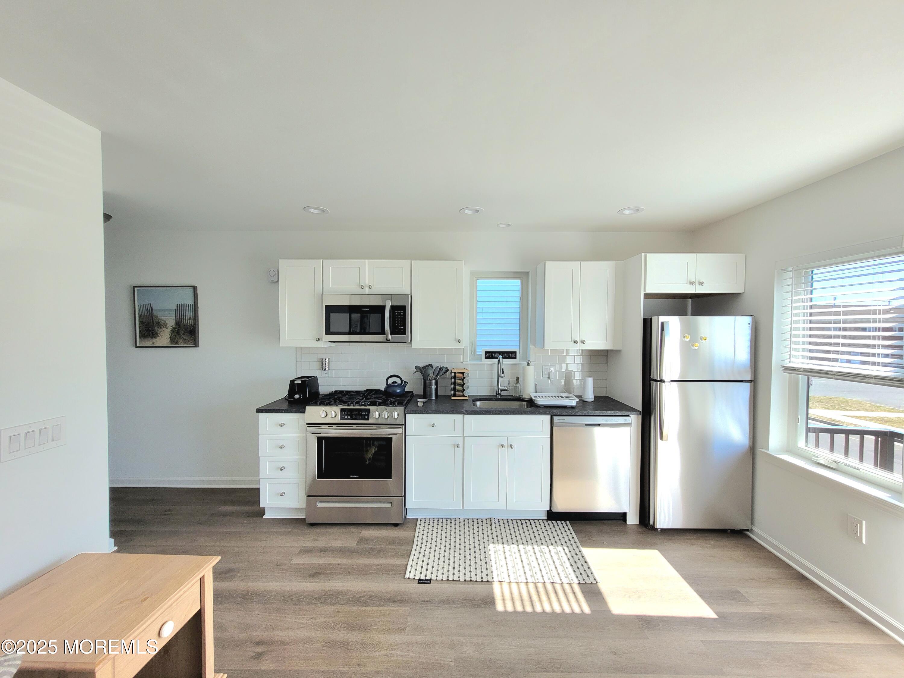 1134 Springwood Avenue, Unit B Asbury Park, NJ 07712 - Photo 11 of 19 a kitchen with white cabinets and white appliances