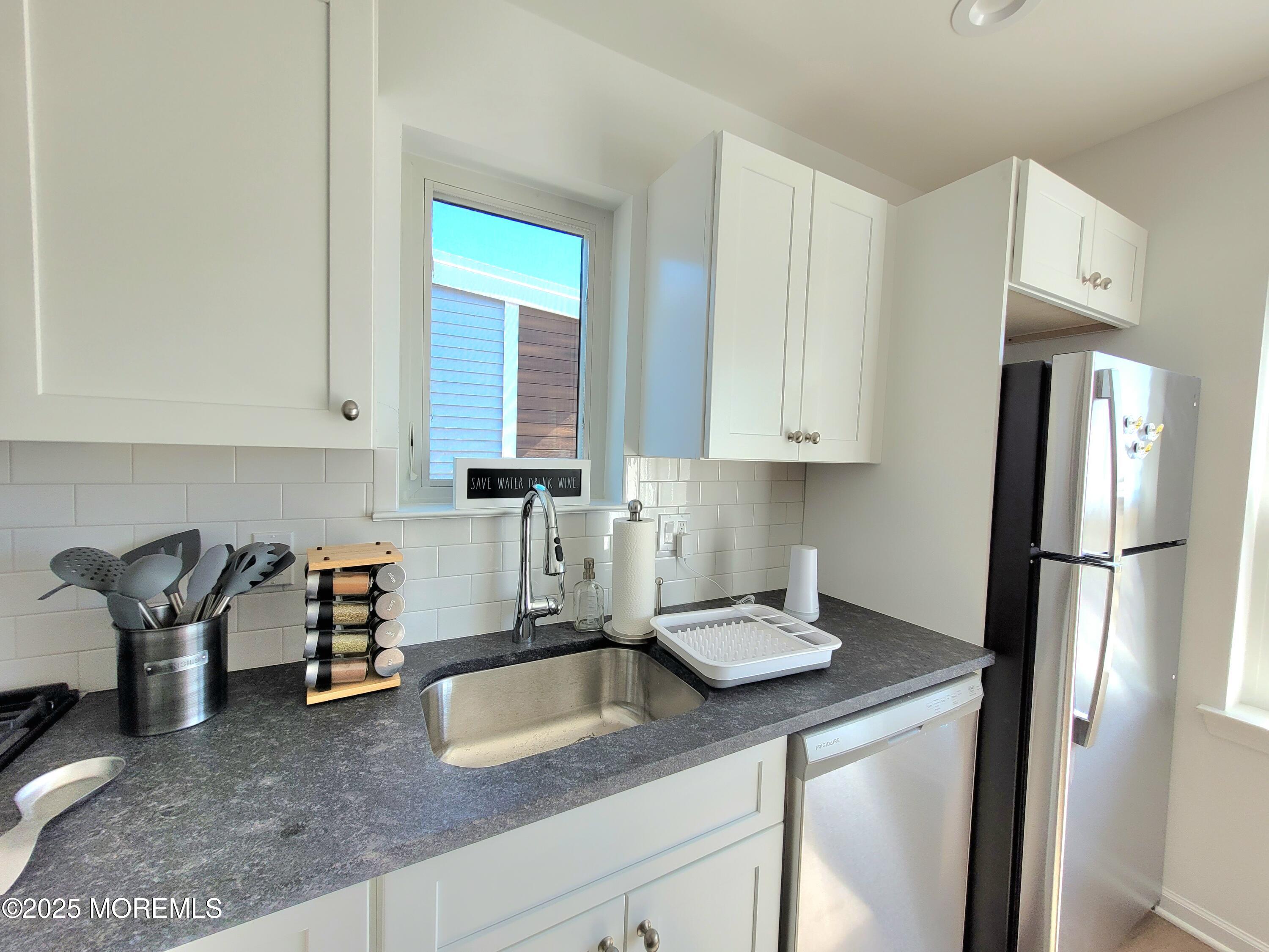 1134 Springwood Avenue, Unit B Asbury Park, NJ 07712 - Photo 9 of 19 a kitchen with stainless steel appliances granite countertop a refrigerator sink and white cabinets
