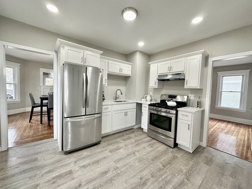 38-40 Pasadena Street Springfield, MA 01108 - Photo 2 of 37 a kitchen with a refrigerator a stove top oven a sink and a center island