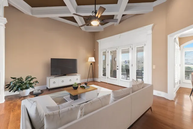 a dining room with wooden floor a chandelier a wooden table and chairs
