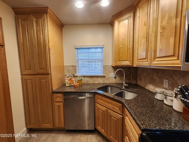 a kitchen with granite countertop a sink and a refrigerator