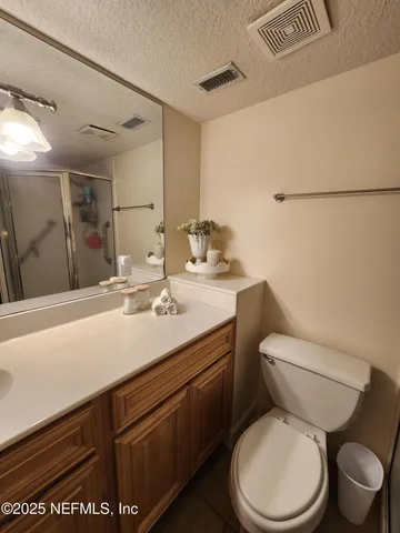 a bathroom with a granite countertop toilet sink and mirror
