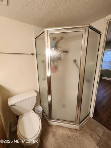 a white toilet sitting next to a shower