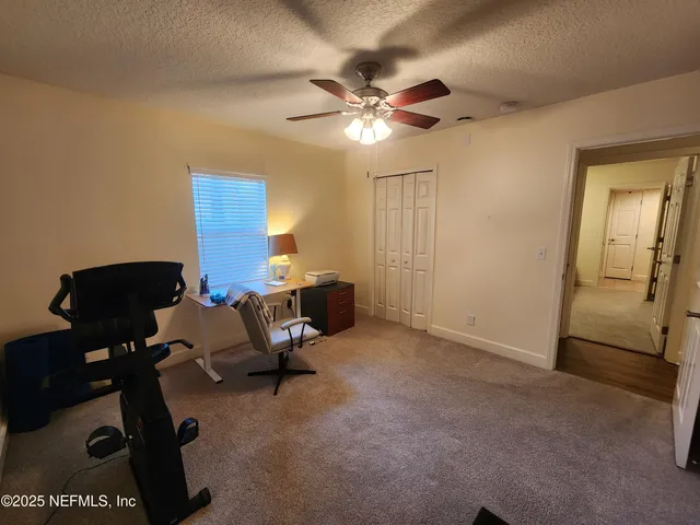 a view of a workspace with furniture and a window