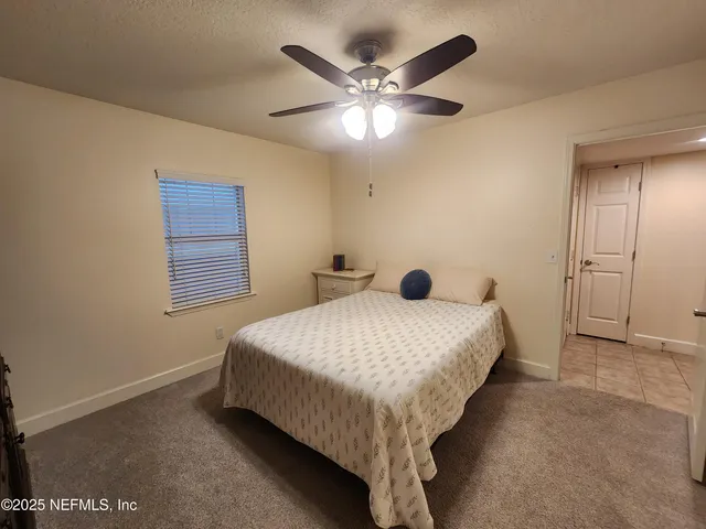 a bedroom with a bed and a ceiling fan