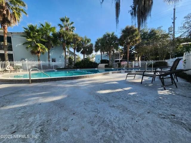a row of palm trees in front of a house