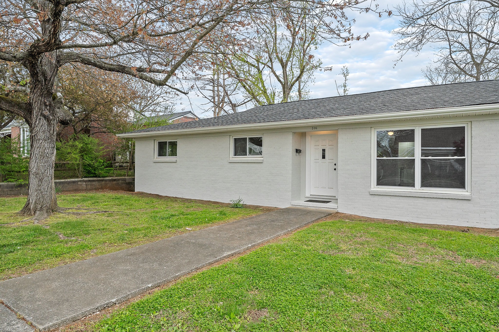 106 North Main Street Sparta, TN 38583 - Photo 3 of 28 a backyard of a house with plants and large tree