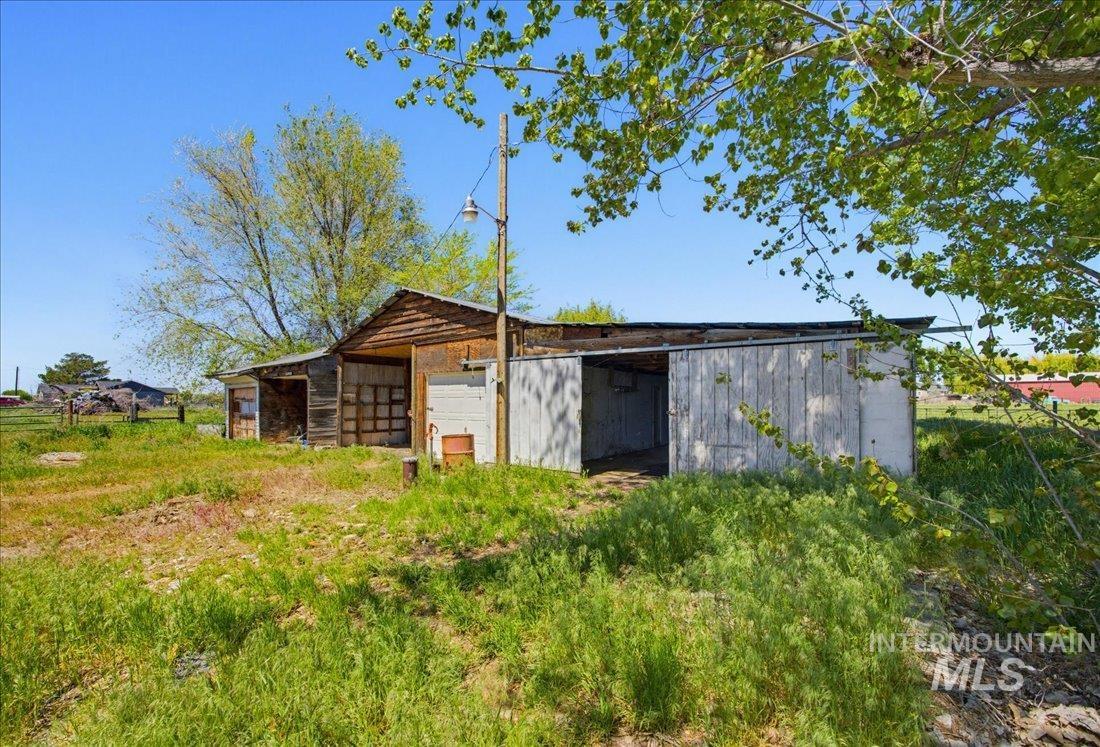 30013 Apple Valley Road Parma, ID 83660 - Photo 25 of 25 Rustic outbuilding with wood siding and open-sided sections, featuring an overhead light fixture