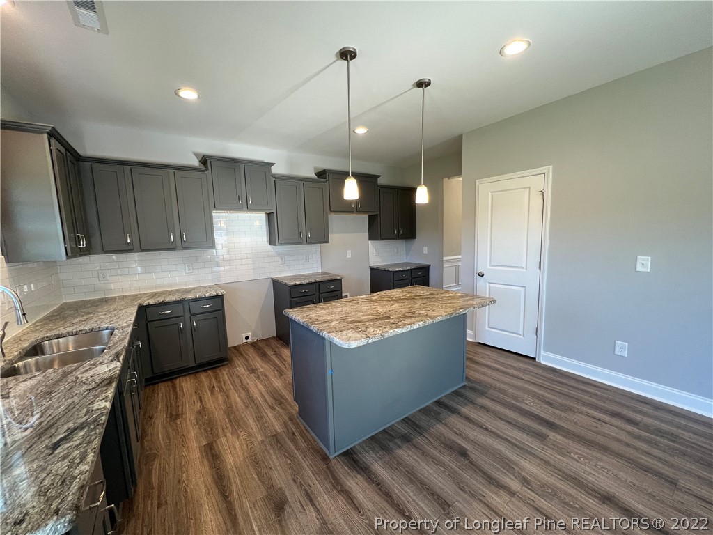 7810 Rufus Johnson Road St. Pauls, NC 28384 - Photo 4 of 18 a kitchen with kitchen island a counter top space a sink stainless steel appliances and cabinets