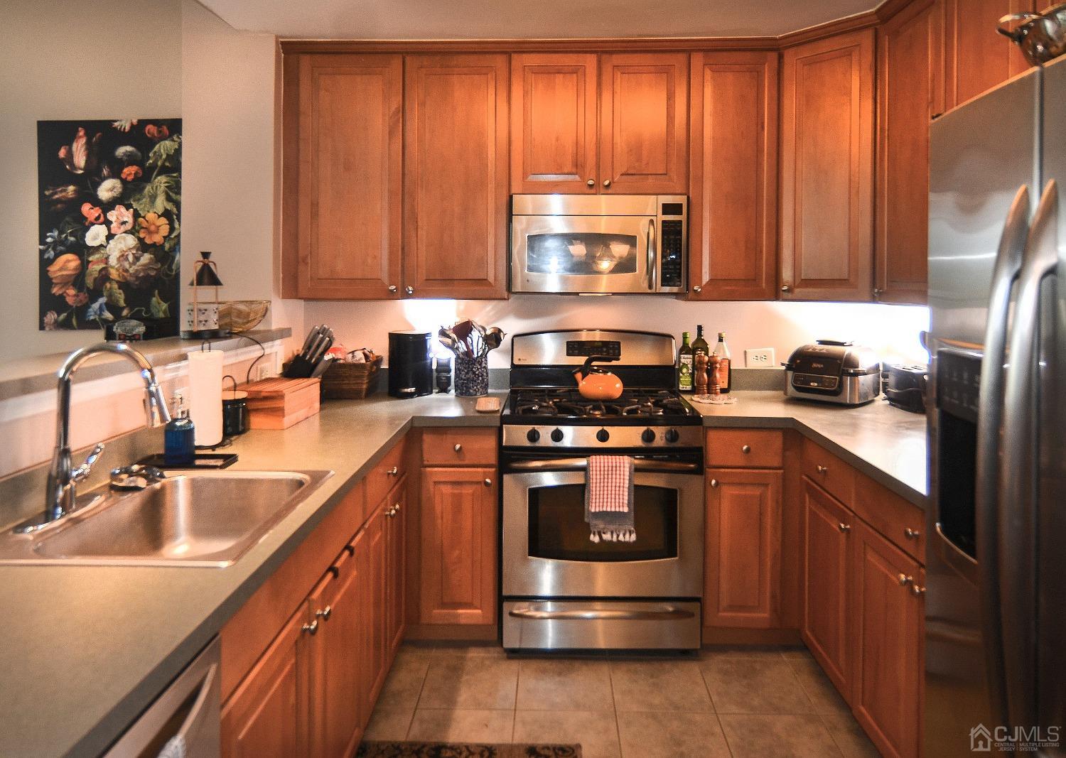 358 Rector Street, Unit 304 Perth Amboy, NJ 08861 - Photo 7 of 28 a kitchen with stainless steel appliances granite countertop a sink stove and refrigerator