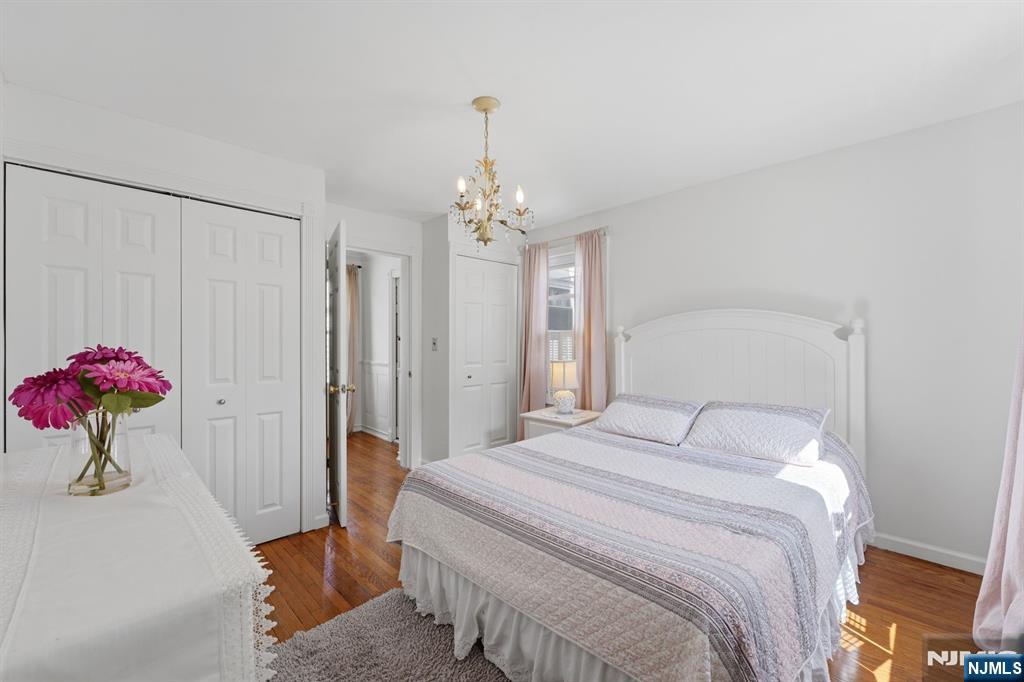 385 Berkeley Avenue Bloomfield, NJ 07003 - Photo 15 of 39 a bedroom with a bed and a chandelier
