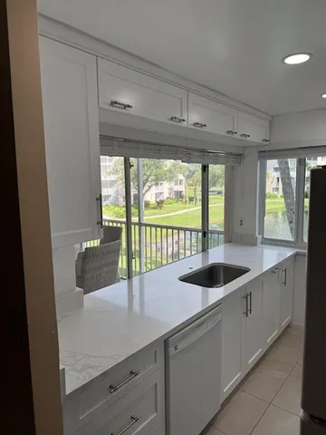a kitchen with stainless steel appliances granite countertop a sink and a large window