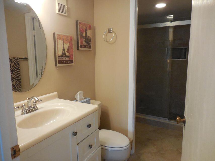 353 Highway 1, Unit A203 Jupiter, FL 33477 - Photo 17 of 26 a bathroom with a sink a toilet a shower and a mirror