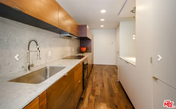 a hallway with sink and wooden floor