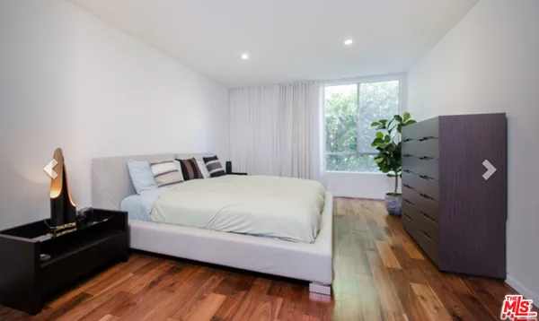 a bedroom with a bed and a potted plant