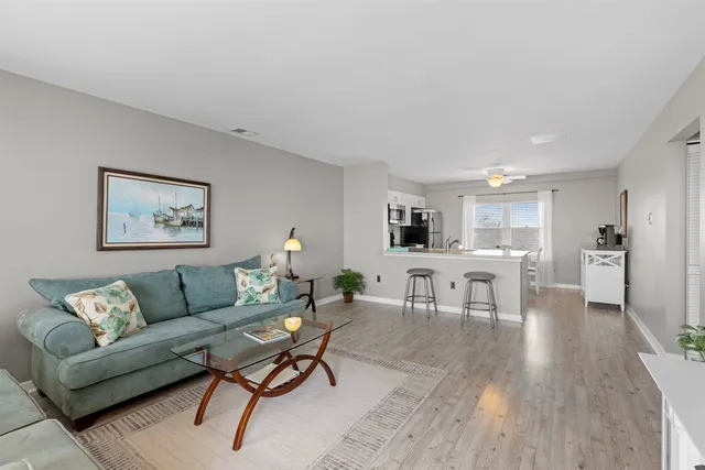 a kitchen with a sink stove and white cabinets with wooden floor