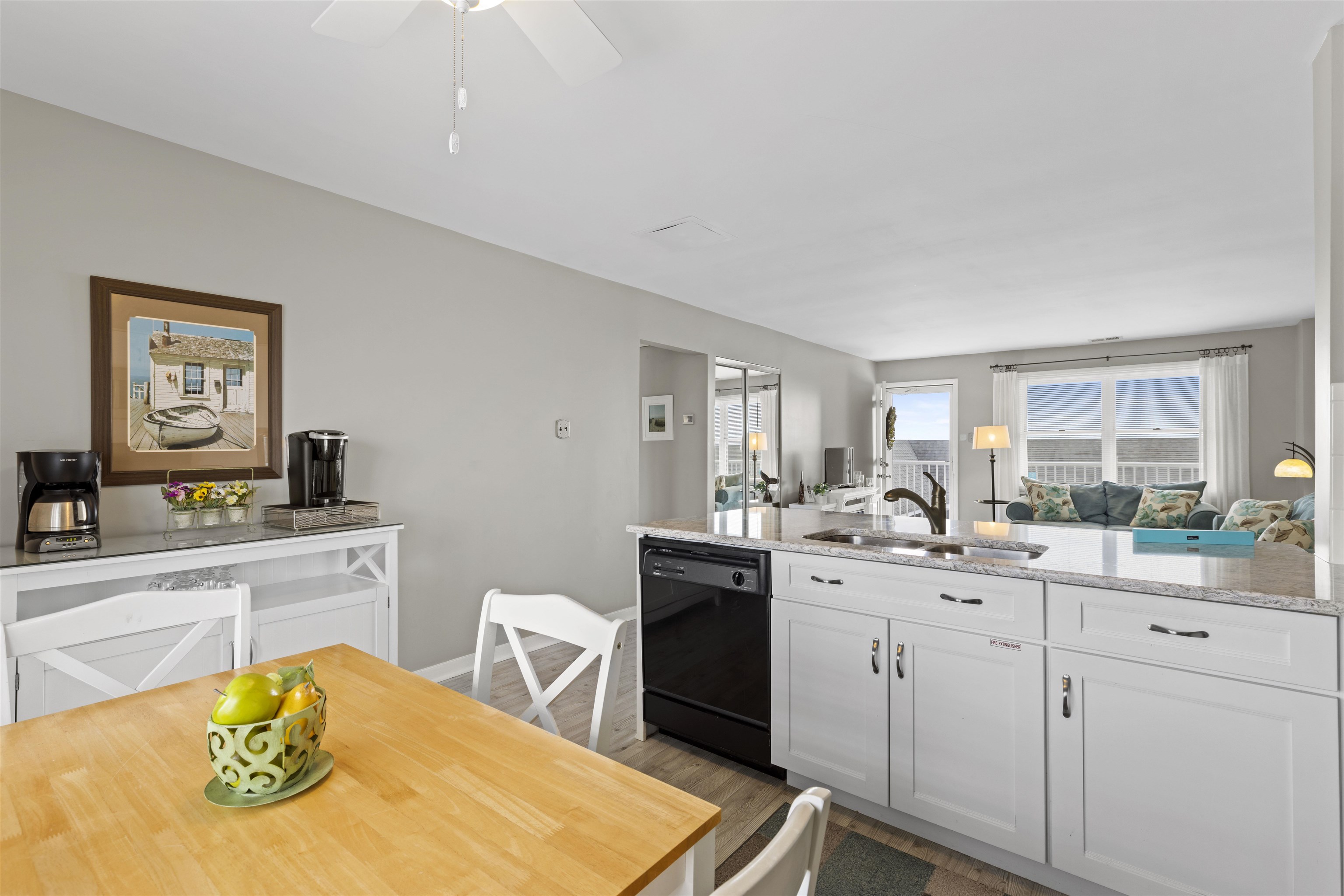 9 Jackson Street, Unit 506 Cape May, NJ 08204 - Photo 14 of 29 a kitchen with a sink stove and white cabinets with wooden floor