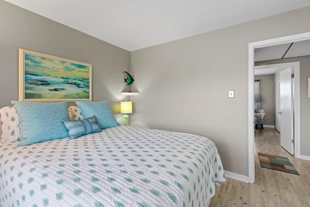 a bedroom with a bed and a painting on the wall