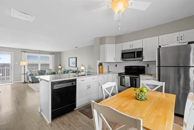a very nice looking dining room with kitchen island granite countertop furniture a large window and a sink