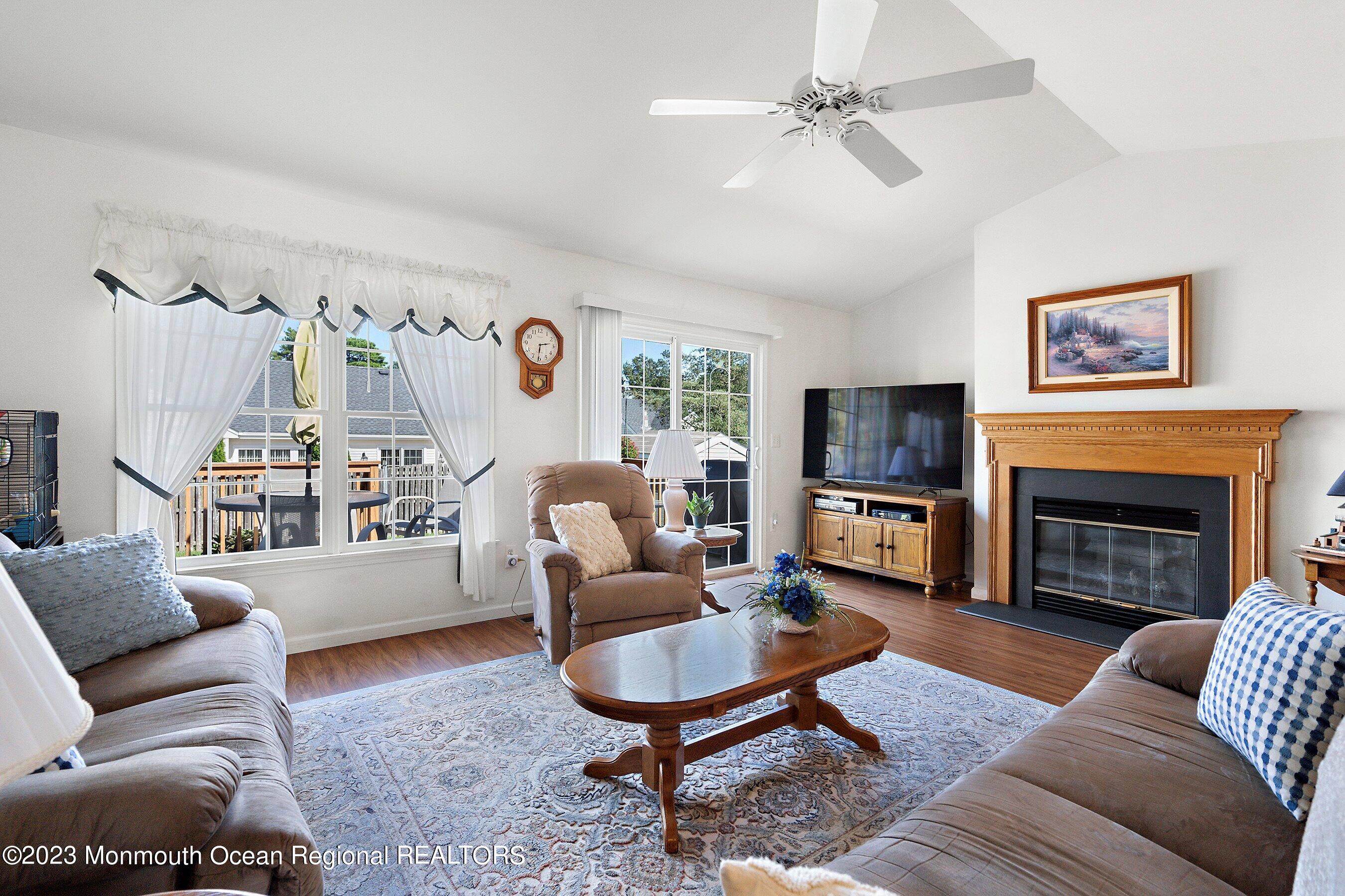 312 Leeward Road Manahawkin, NJ 08050 - Photo 13 of 25 a living room with furniture a flat screen tv and a fireplace
