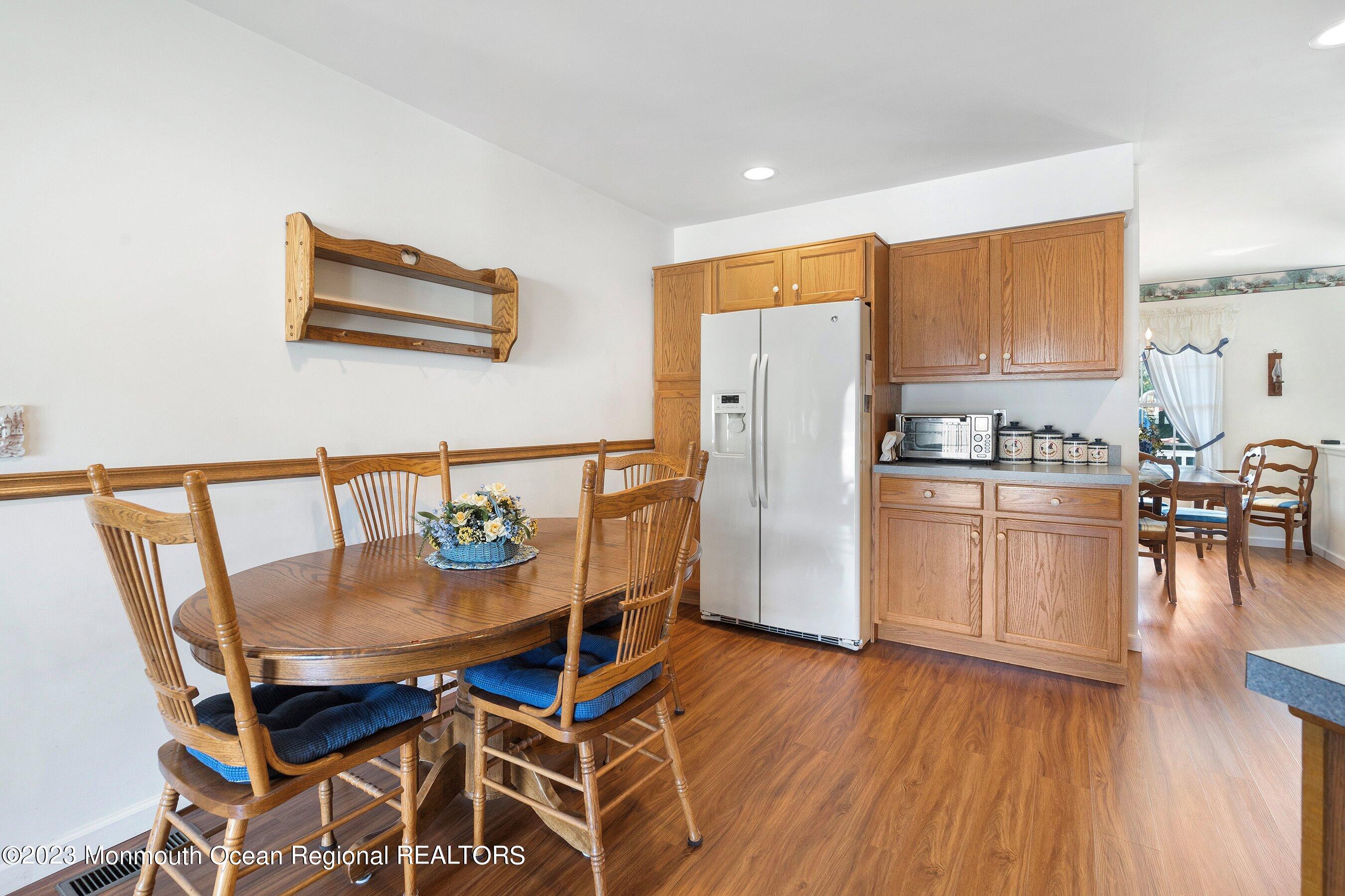 312 Leeward Road Manahawkin, NJ 08050 - Photo 7 of 25 a kitchen with stainless steel appliances granite countertop a stove top oven a dining table and chairs with wooden floor