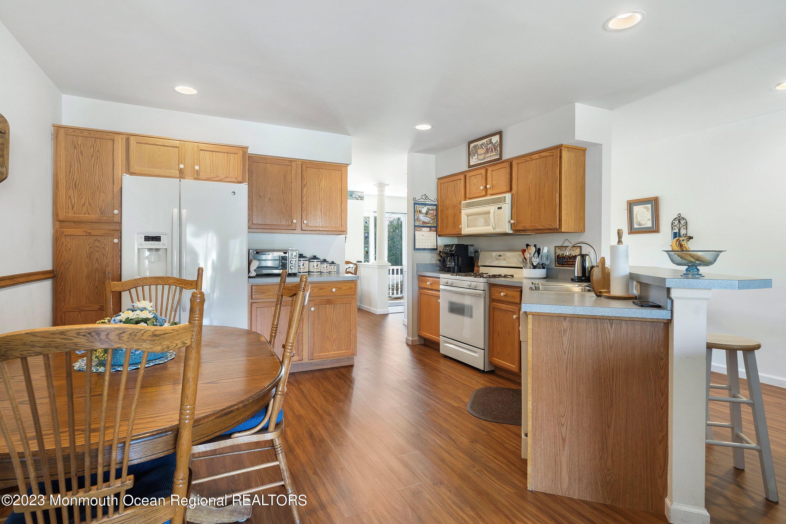 312 Leeward Road Manahawkin, NJ 08050 - Photo 9 of 25 a kitchen with stainless steel appliances kitchen island granite countertop a stove a sink a dining table and chairs