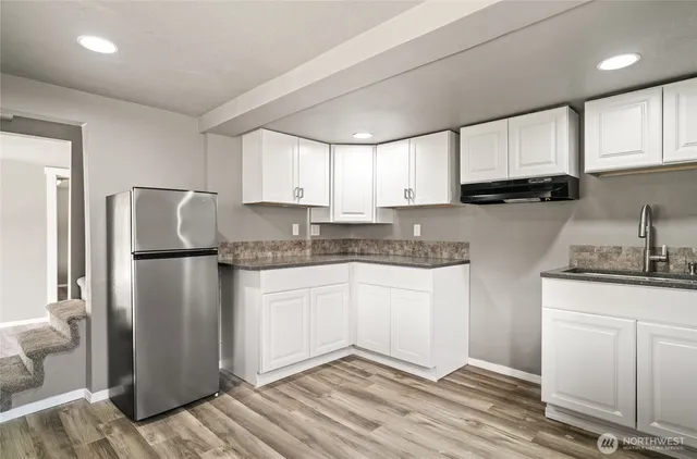a kitchen with a refrigerator sink and cabinets