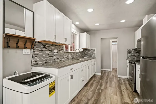 a kitchen with granite countertop a sink stove and refrigerator