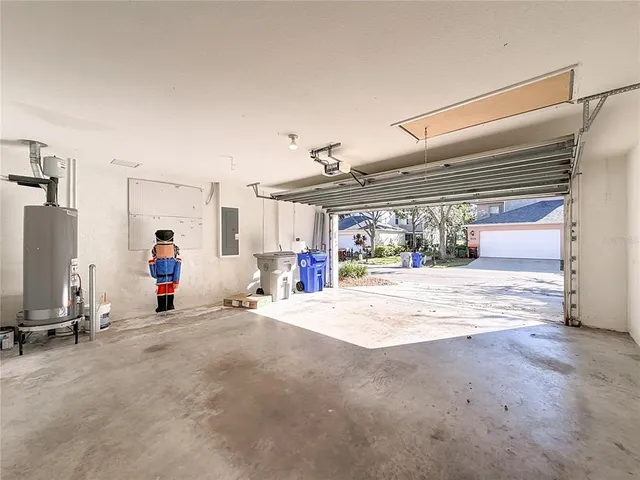 an aerial view of a house with a yard and large tree