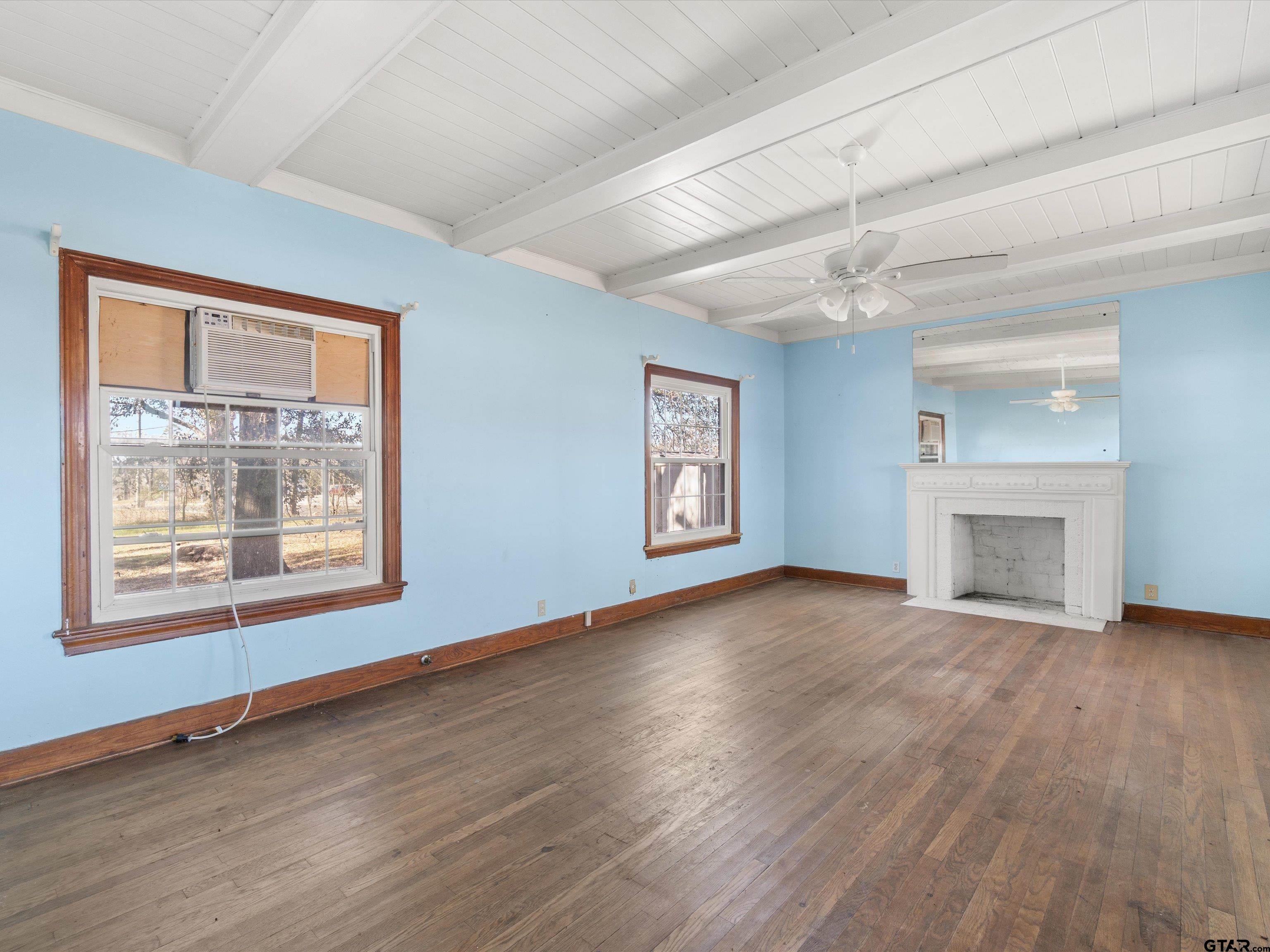 102 South Front Street Overton, TX 75684 - Photo 13 of 22 an empty room with wooden floor fireplace and windows