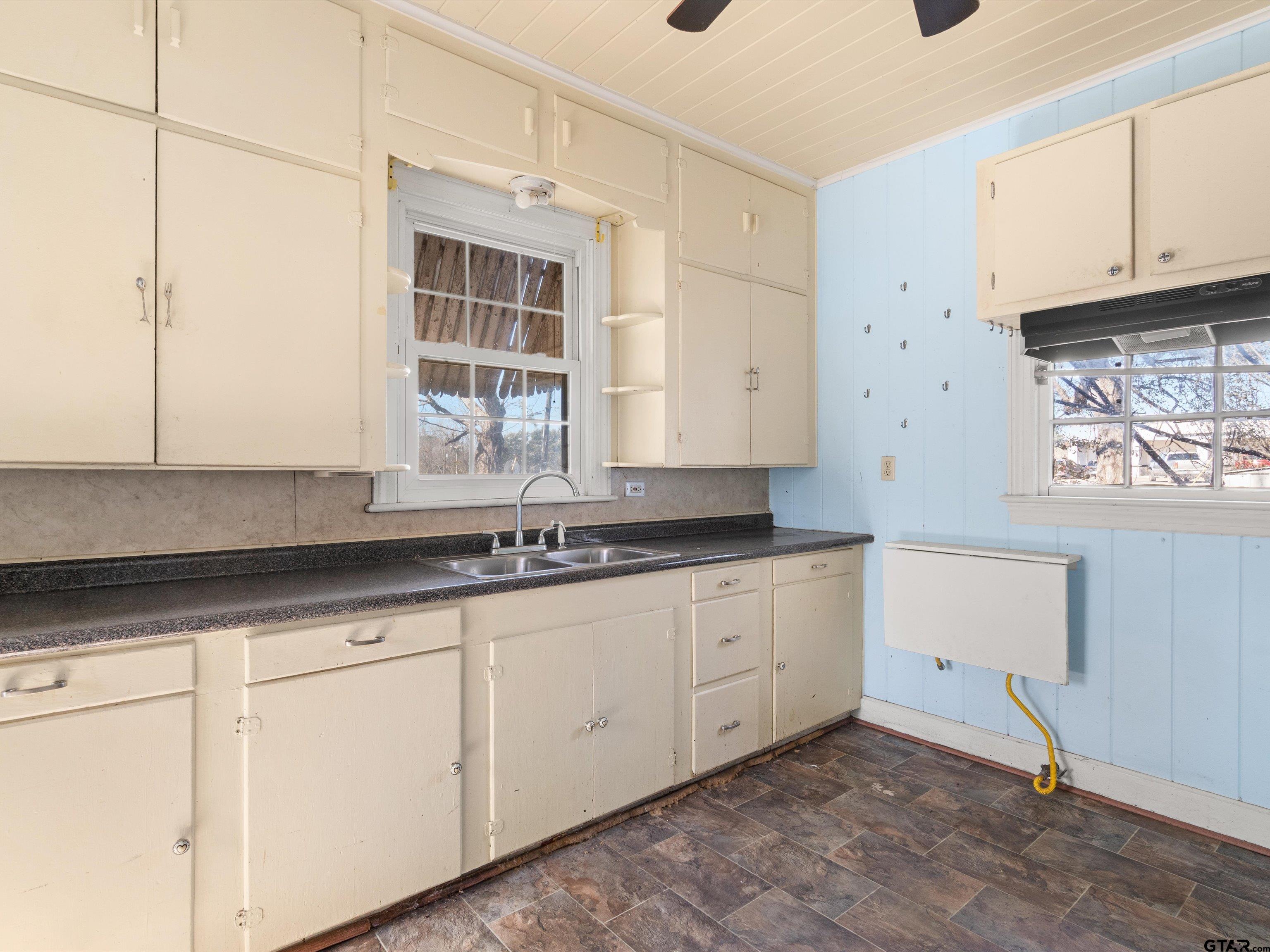 102 South Front Street Overton, TX 75684 - Photo 16 of 22 a kitchen with granite countertop white cabinets and a sink