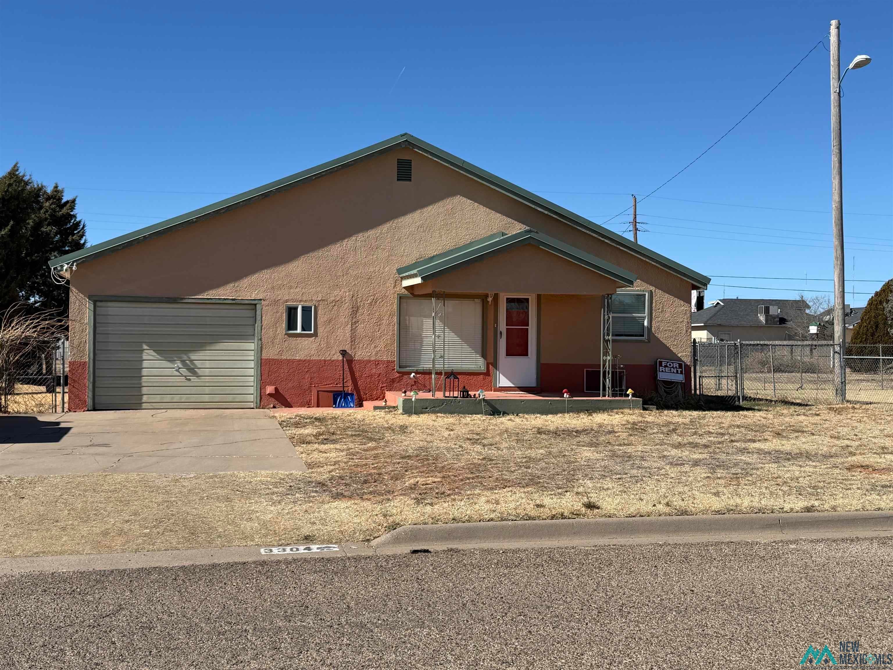 3304 Lilac Road Clovis, NM 88101 - Photo 1 of 1 View of front of house featuring a garage, stucco siding, a porch, and concrete driveway