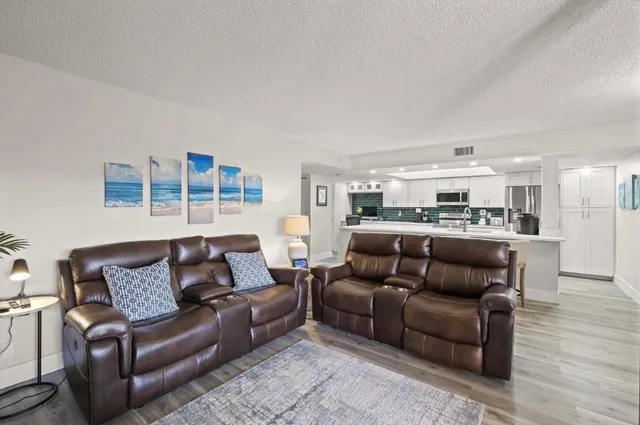 a living room with furniture and kitchen view