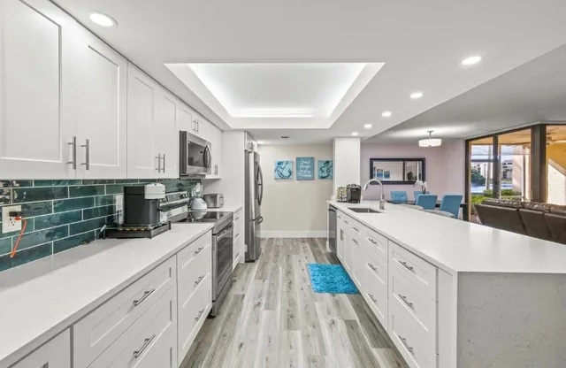 a large kitchen with stainless steel appliances granite countertop a lot of counter space and wooden floors