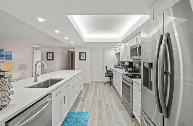 a large kitchen with stainless steel appliances granite countertop a lot of counter space and wooden floors