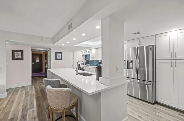 a kitchen with stainless steel appliances granite countertop a refrigerator and a sink