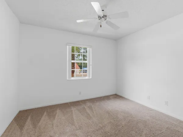a view of an empty room with a ceiling fan
